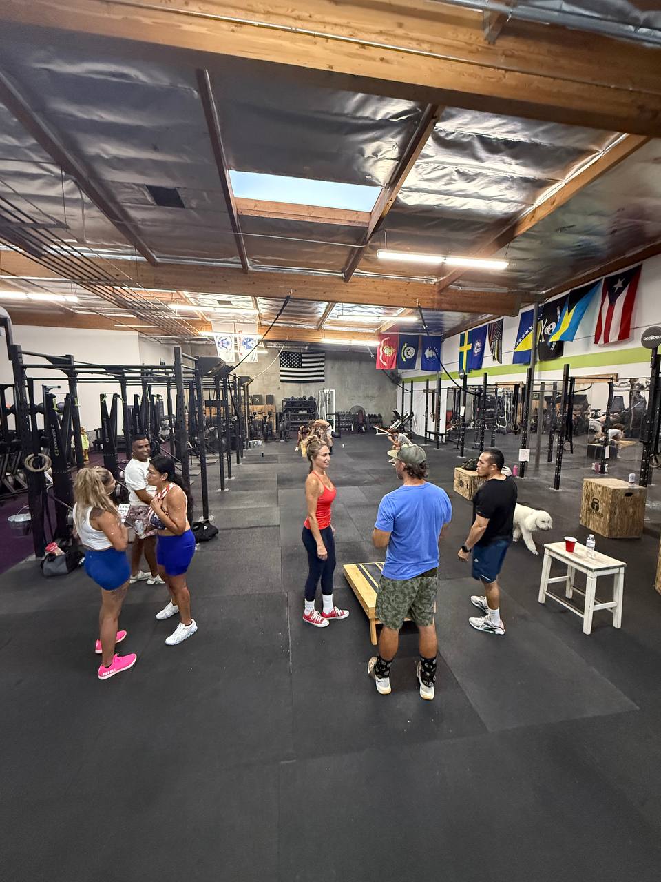 Members gathered inside the gym with flags on the wall on Freedom WOD night