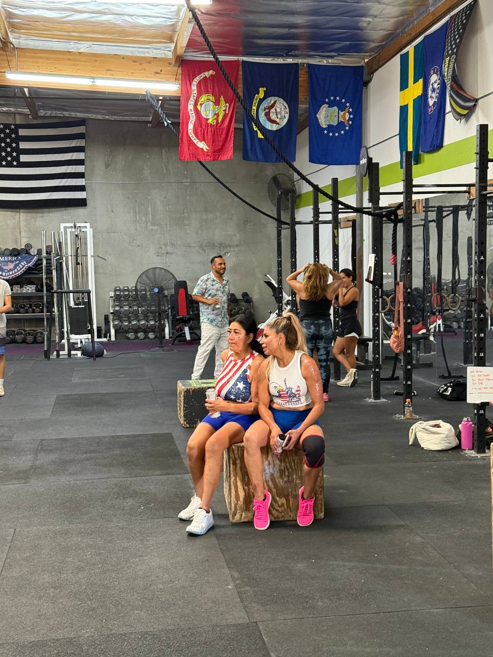 Two members in patriotic tanks taking a breather on the boxes